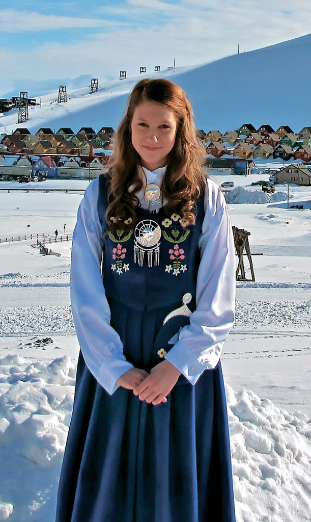 Норвежская девушка в национальном костюме, надетом в честь Дня Независимости Норвегии, 17 мая на фоне Лонгйербина. Как видите, в это время там ещё очень много снега. 
