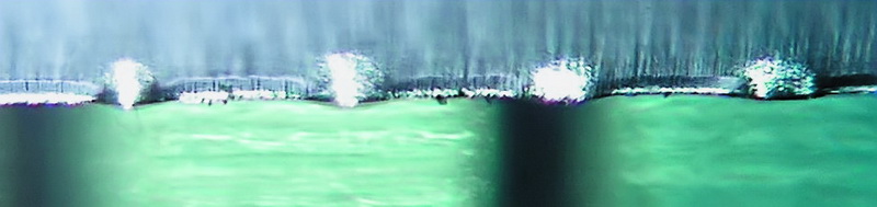 Рисунок 10. Лезвие под микроскопом с боковой подсветкой. Внизу - прозрачная линейка с миллиметровыми делениями.