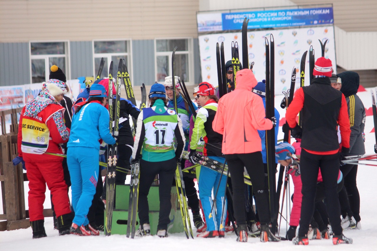 Спортсменки по очереди проходят чипование и маркировку лыж.