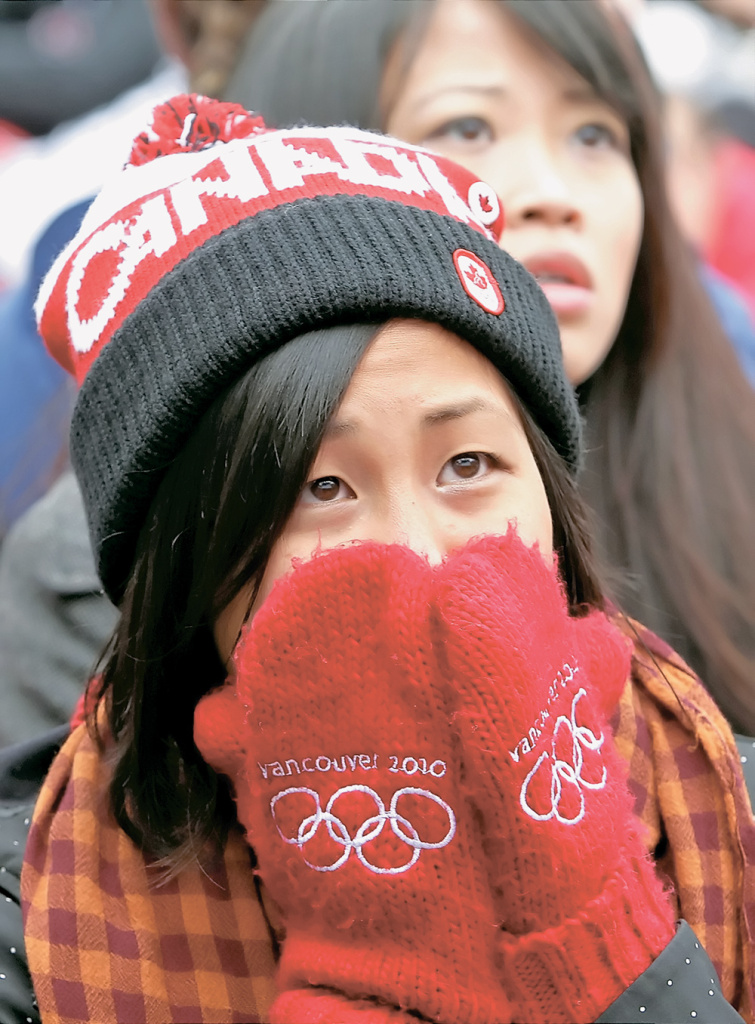 Одна из болельщиц на трибунах стадиона в Ванкувере...Кстати, с этими рукавичками с символикой Олимпиады связана целая история — канадцы умудрились создать вокруг них самую настоящую интригу. Рассказывают, что продавались эти рукавички только в одном месте — в центральном универмаге Ванкувера (или как он в Канаде может называться — торговом центре?). Чтобы купить эти недорогие рукавички (по-моему, они стоили то ли 10, то ли даже пять канадских долларов), нужно было выстоять огромную многочасовую очередь. Опять-таки, рассказывают, что, несмотря на страшный дефицит, рукавички эти были у всех и везде, но для того, чтобы стать их обладателем, нужно было здорово потрудиться. То есть канадцы сумели и ажиотаж создать, и продать какое-то совершенно несметное количество этих рукавиц...Иван ИСАЕВ