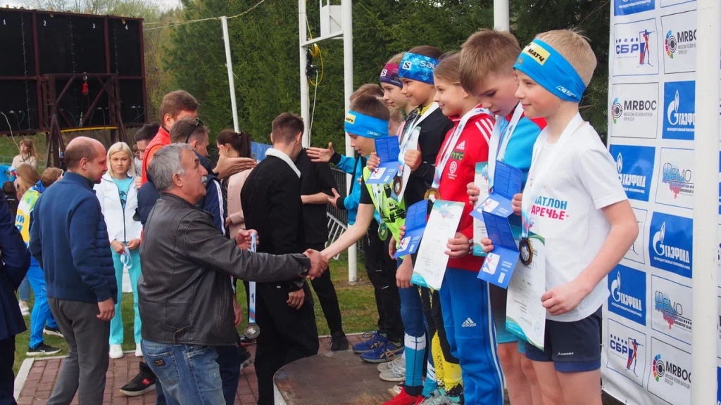Юных биатлонистов награждает заслуженный тренер России Александр Касперович.