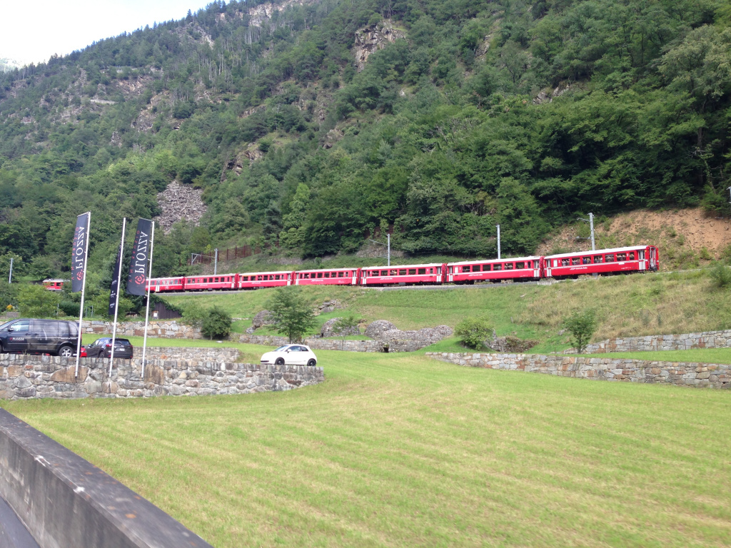 Городок Тирано связан со Швейцарией железной дорогой, по которой курсирует вот такой практически игрушечный поезд. Пересечь Альпы на красном поезде - настоящее приключение. Этот поезд называется Bernina Express, в 2008 году он получил статус Всемирного Наследия ЮНЕСКО. Маршрут из Тирано в швейцарский Санкт-Мориц является уникальным - это самая высокогорная дорога Европы, маршрут достигает высоты 2253 м над уровнем моря. На пути открывается вид на ледник Morteratsch Glacier (Массив Бернина). Если выйти на станции Diavolezza, то на канатной дороге можно добраться до ледника (каждые 20-30 минут отправление). Кстати, Санкт-Мориц находится примерно в часе езды на машине от Ливиньо, также от станции Diavolezza можно добраться до курорта на автобусе (https://www.rhb.ch/en/panoramic-trains/bernina-express).